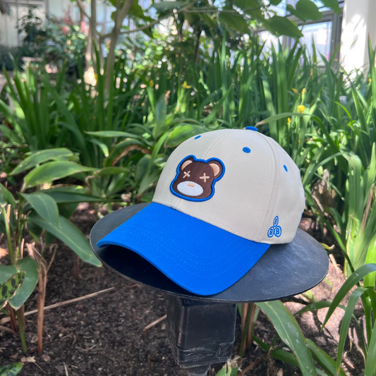 White and blue cap with bear design on a stand outdoors