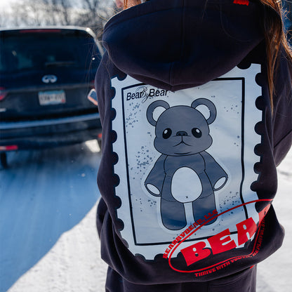 Person wearing a hoodie with a bear graphic and 'Bear' text on the back, standing outdoors.